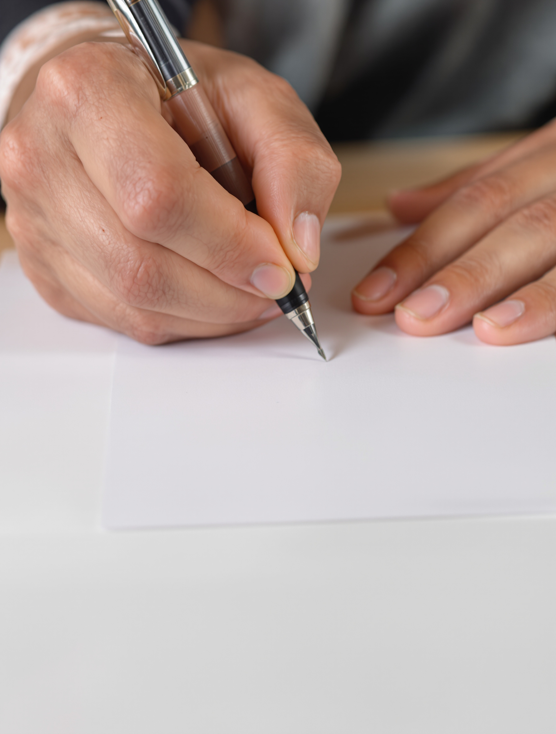 Personne écrivant à la main sur le formulaire MDPH, plan serré sur les mains et le stylo.